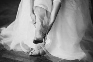 panna młoda zakłada buty przed ślubem