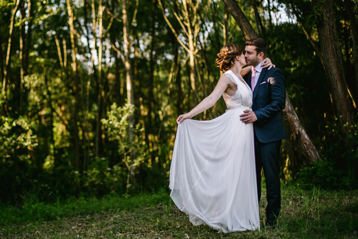 a man and woman in a suit kissing in the woods, wedding photography